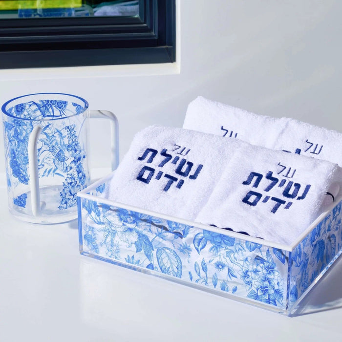 Blue and white French toile washing cup with coordinating towels and decorative pitcher displayed on vanity.