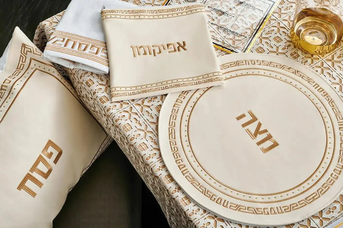 Geometric Crystal Stone Pesach Set with leather accents in cream and gold tones, featuring decorative plates and matching serving pieces arranged on neutral fabric.