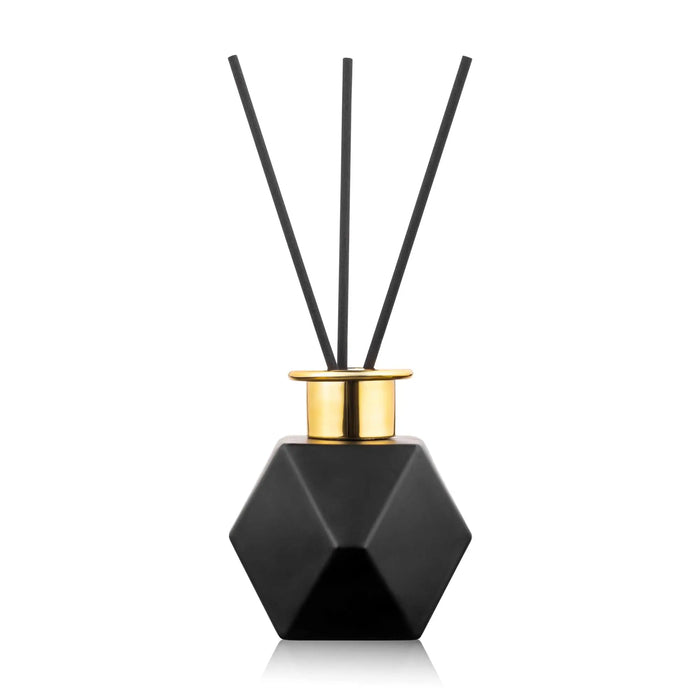 Black geometric hexagonal diffuser with gold trim and three reed sticks by Waterdale Collection