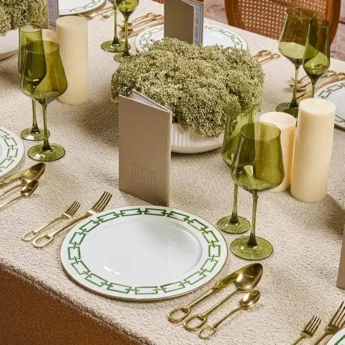 Cream greenery white flower pot displayed on elegant table setting with green wine glasses and place settings, perfect for home decor or entertaining.