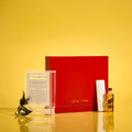 Red Hadlokas Neiros Tzedakah Box for Purim mishloach manos gifts, displayed with decorative items on yellow background.