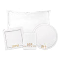 Hemstitched Pesach set with white linens including tablecloth, napkins, plate charger, and matching dinnerware in elegant leather trim design.