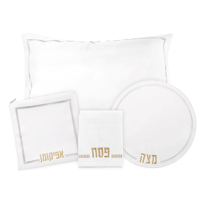 Hemstitched Pesach set with white linens including tablecloth, napkins, plate charger, and matching dinnerware in elegant leather trim design.