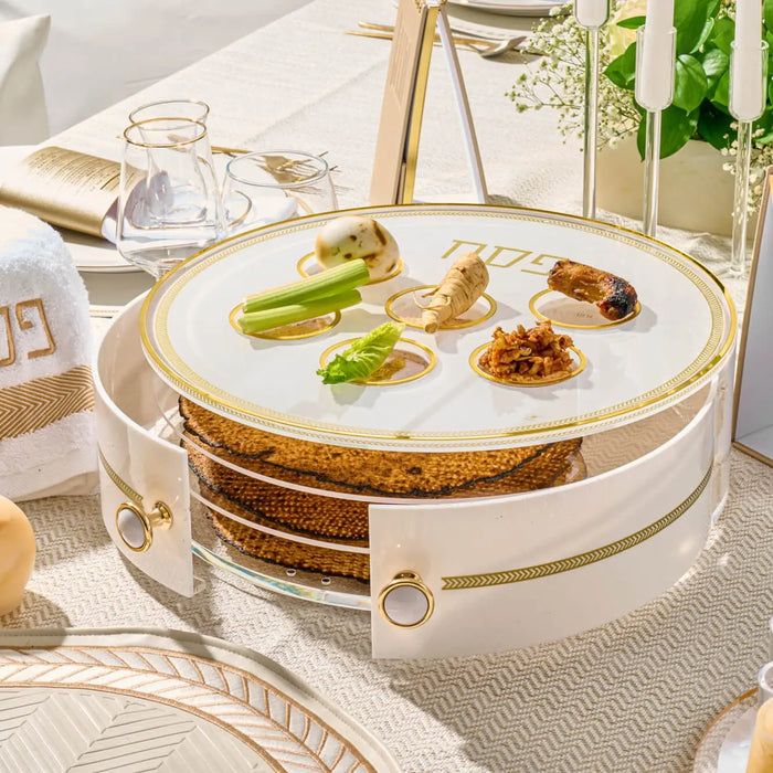 Herringbone 3 level Seder plate with lucite construction, featuring gold trim and three stacked compartments displaying traditional Passover foods on white tabletop.