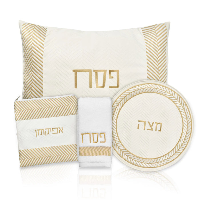 Herringbone Pesach set with cream and gold pieces including pillow cover, matzah cover, plate, and afikoman bag featuring Hebrew text and geometric stripe pattern.