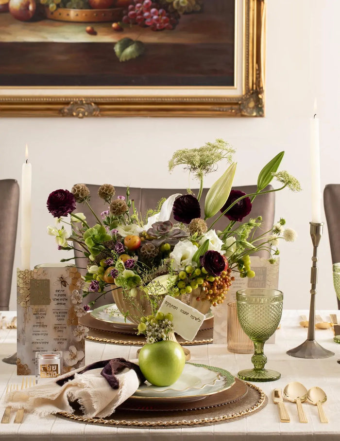 Painted honeycomb simanim card alongside a personal suspended honey dish on a Jewish New Year table