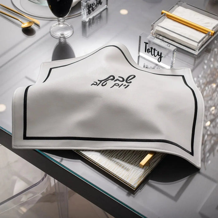 Silver leather Hotel Style Challah Cover from Waterdale Collection displayed on table with tabletop decor for Shabbat