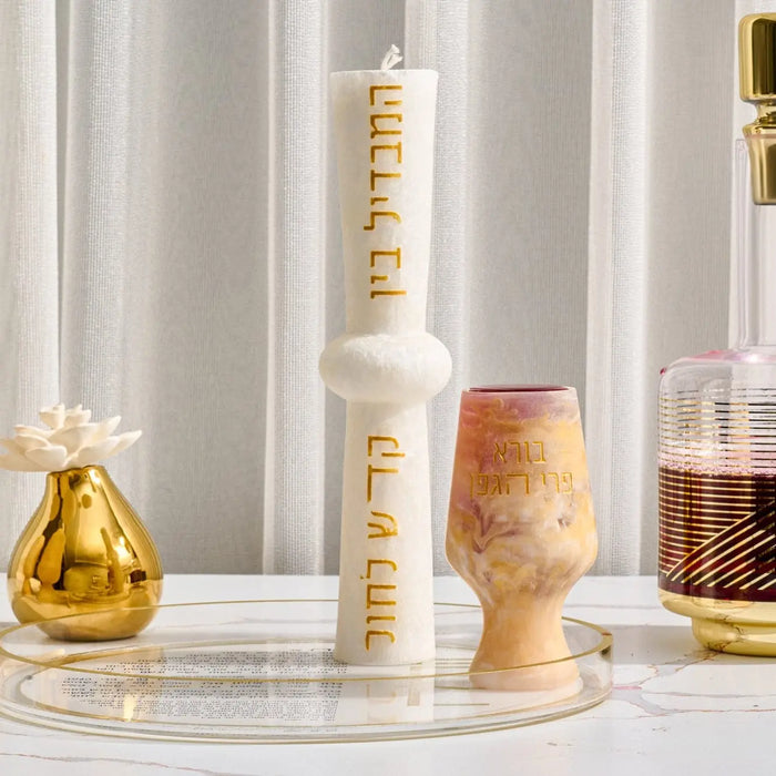 Hourglass Havdalah Candle in cream and gold tones displayed on marble surface with matching ceremonial vessels and glassware.