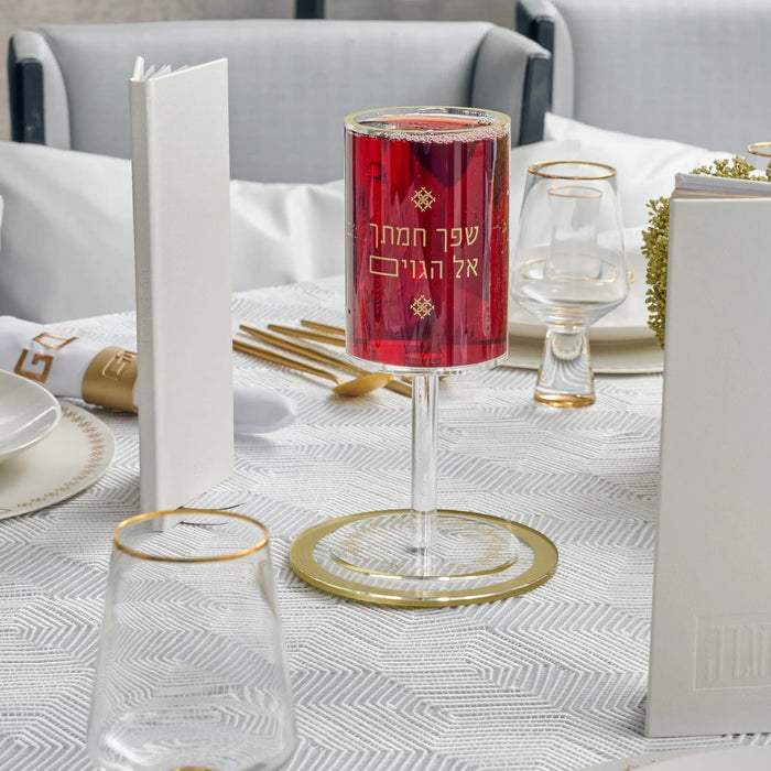 Clear lucite Inspired Kos Shel Eliyahu kiddush cup displayed with matching tabletop accessories in a styled flatlay setting.