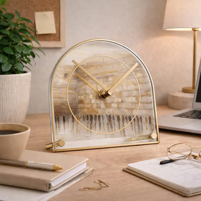 Jerusalem Taupe Basic Desk Clock by Waterdale Collection featuring a round metal face with minimalist design, displayed on a wooden desk with office supplies and lamp.