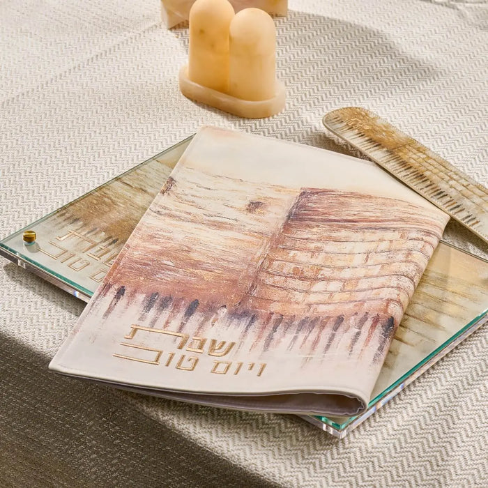 Jerusalem Taupe Challah Cover in soft leather with traditional Kosel design, displayed on table with candlestick and prayer book.