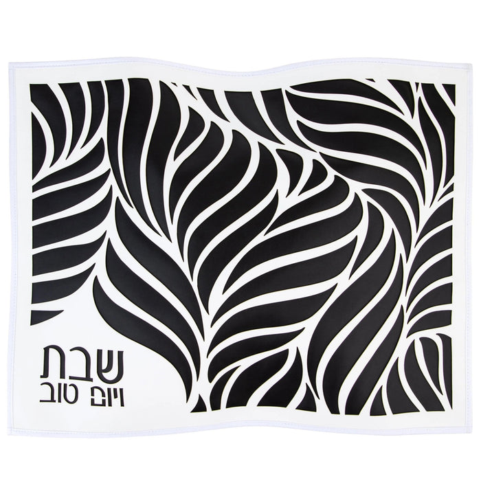 Black leather challah cover with intricate leaf laser cut design and Hebrew text, perfect for Shabbat table.