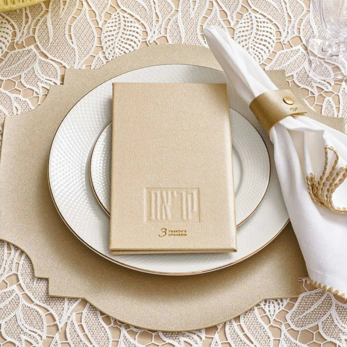 Cream leather Shema prayer book on white plate with napkin and utensils in elegant table setting