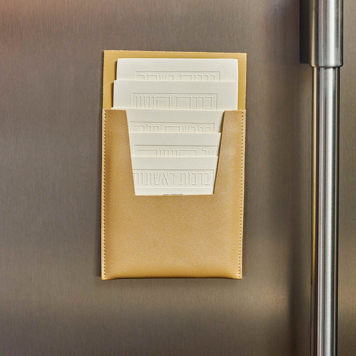 Tan leather magnetic brachos set displayed on refrigerator showing white printed cards for Jewish blessings by Waterdale Collection