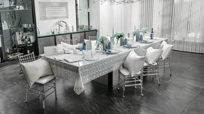 Gold and silver leather Seder card napkin wraps arranged on a formal dining table set for Pesach, showcasing elegant tabletop décor.