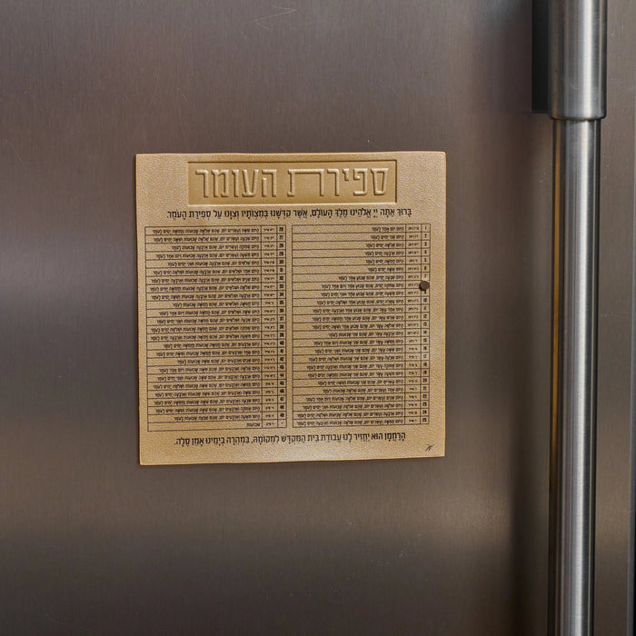 Tan leather Sefiras Haomer magnet displaying Hebrew text calendar grid for counting the Omer during Pesach holiday observance.