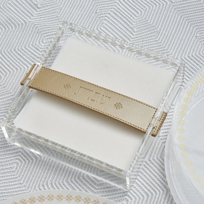 Leather Strap Inspired Napkin Holder in cream and gold by Waterdale Collection, displayed on a textured white surface