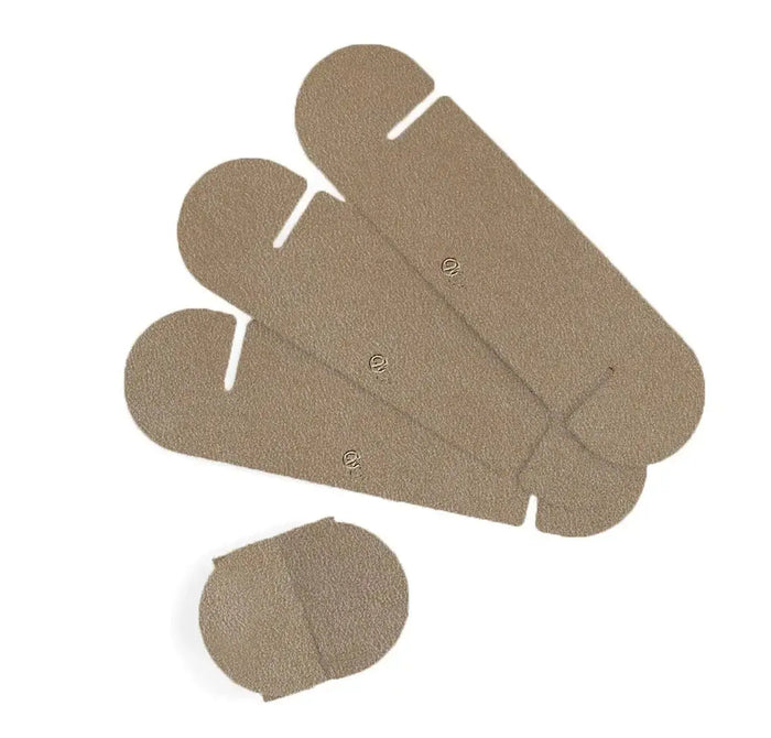 Four tan leatherette Loop Napkin Wraps with white stitching detail, displayed fanned out with one single wrap shown below, perfect for Shabbat and holiday table settings.