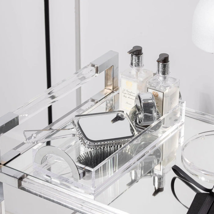 Clear acrylic Luxe Bread Tray displaying toiletries and vanity items on a white bathroom counter, metal accents visible.