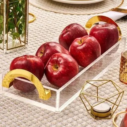 White metal luxe bread tray filled with red apples and lemon slices, styled on a textured surface with gold accessories and tableware
