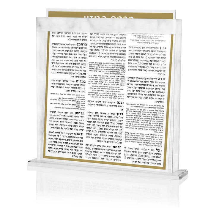 Marble and clear acrylic bencher set with gold trim displaying Hebrew text pages, ideal for Shabbat and holiday table settings.