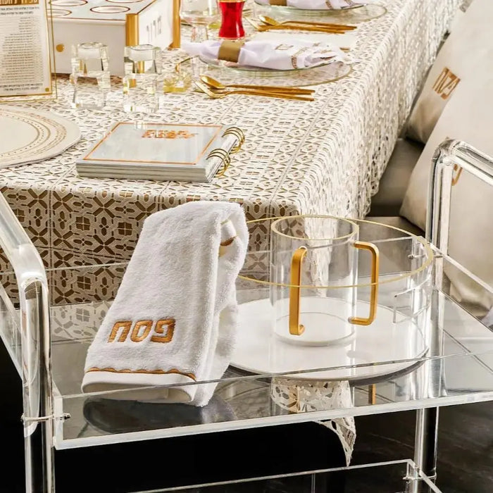 Metallic washing cup displayed on a bathroom vanity shelf with toiletries and decorative items, showing its shiny finish and elegant design.