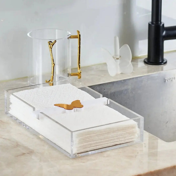 Gold metal Waterdale Collection MetaLucite Twig Washing Cup on white marble vanity, displayed next to bathroom accessories