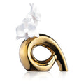 Gold curved Mod Floral Diffuser with white orchid accent, modern sculptural design for home fragrance and wellness.