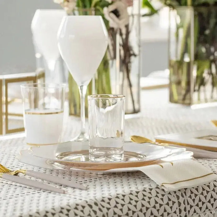 Modern glass Kiddush cup with clear saucer on white table setting with flowers and tableware