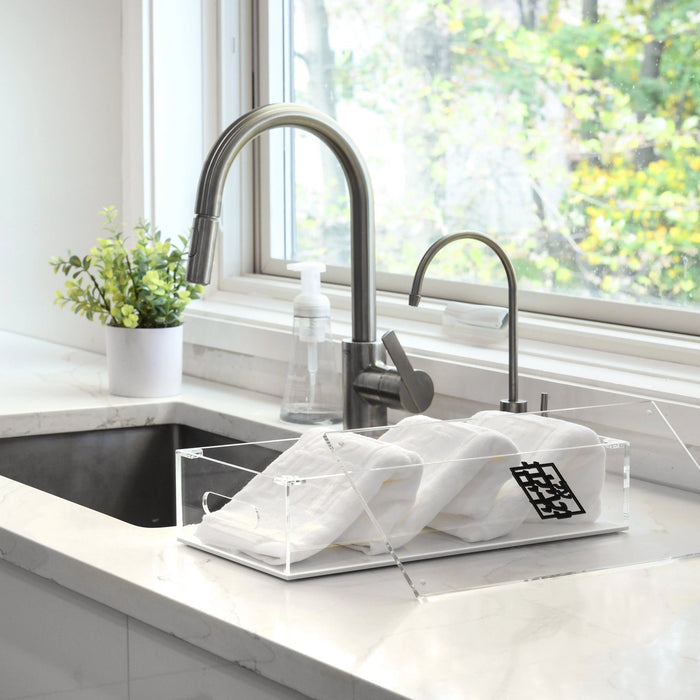 Waterdale Netilas Yadayim Towel Box with folded white towels displayed on a kitchen sink counter near a faucet