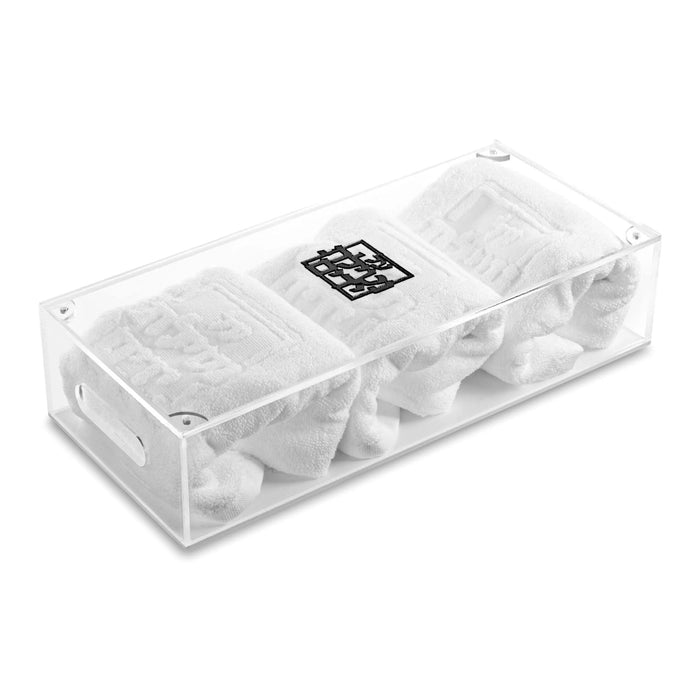 Clear plastic Netilas Yadayim towel box by Waterdale Collection containing rolled white towels, displayed against white background.