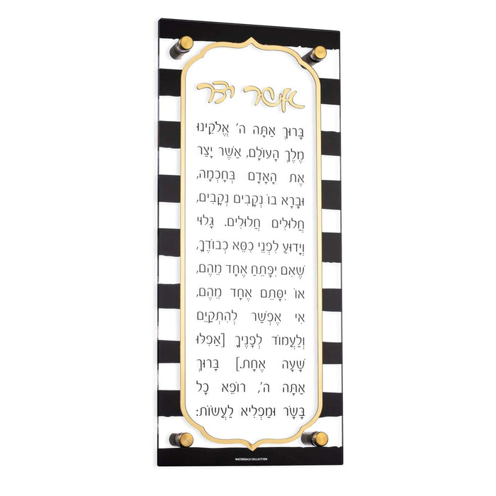 Onyx Asher Yatzar wall art with black and white striped border featuring Hebrew prayer text in gold lettering on cream background.
