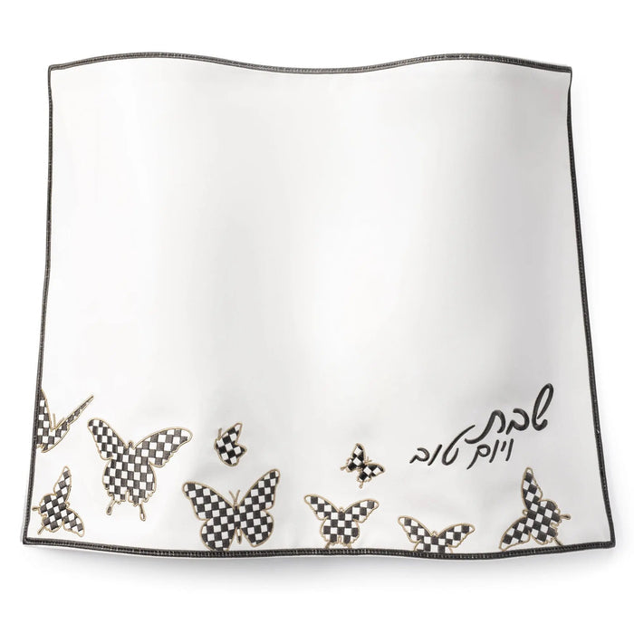 Onyx Butterfly Challah Cover with delicate butterfly and floral embroidery detail along the bottom hem in gold and silver tones on white fabric.