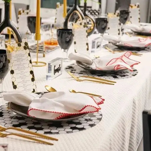 Onyx Chargers by Waterdale Collection displayed on a formal dinner table setting with place settings and gold accents.