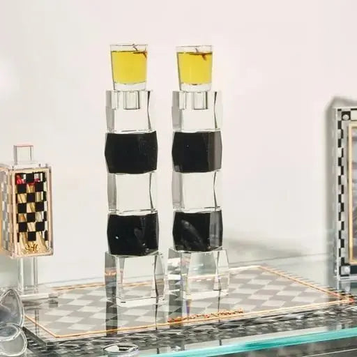 Onyx Hadlokas Neiros tray with black and white striped glass holders and yellow caps for Shabbat candle lighting.