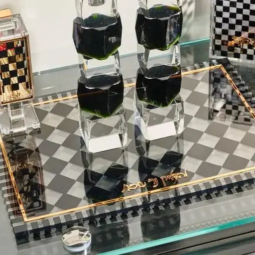Onyx Hadlokas Neiros tray with five black candle holders arranged on polished stone base, displayed on checkered surface with chess sets nearby.