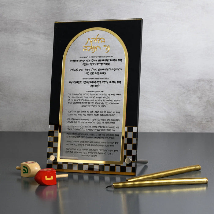 Onyx Chanukah Brachos tabletop in black and white Lucite with gold mirrored detailing, printed with the Hanukkah blessings in Hebrew