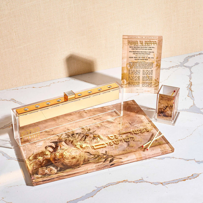 The Painted by Batya Chanukah Block on a marble surface with its matching Chanukah pieces, Batya's artwork printed on Lucite