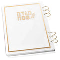 Painted by Batya lucite Haggadah with gold foil text and metallic binding rings on white cover, Pesach holiday book.