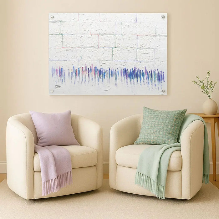 Cream-colored curved armchairs with purple and green throw blankets displayed beneath a framed abstract blue waveform artwork by Yonatan Colored Kosel on a neutral wall.