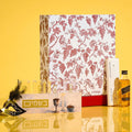 Painted Family Besamim with red and pink floral design on white background, displayed with Purim mishloach manos items on yellow surface.