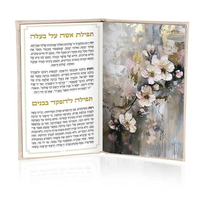 Leather Hadlokas Neiros booklet open showing Hebrew text pages and painted floral design on right cover with white flowers on gray background