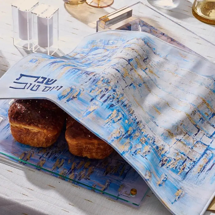 Painted Yosefa challah board with blue watercolor design, wooden handles, displayed with fresh challah bread and Shabbat table setting