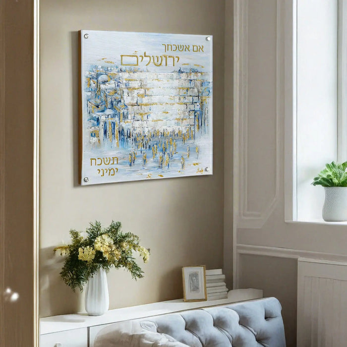 Blue and white painted Yosefa Im Eshkachech wall art hanging above a tufted bench with white flowers, featuring Hebrew text and abstract brushstrokes in a modern home interior.