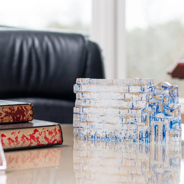 Painted Yosefa Kosel sculpture with blue and white geometric pattern displayed on tabletop near leather chair and decorative boxes