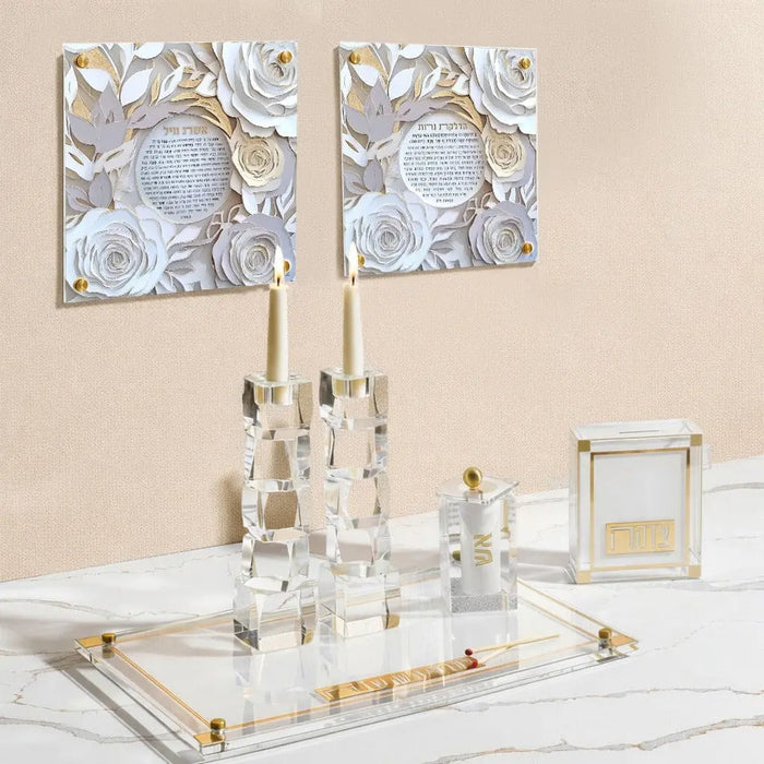 Two framed papercut Eishes Chayil wall art prints with blue and white designs displayed above a white dresser with decorative items.