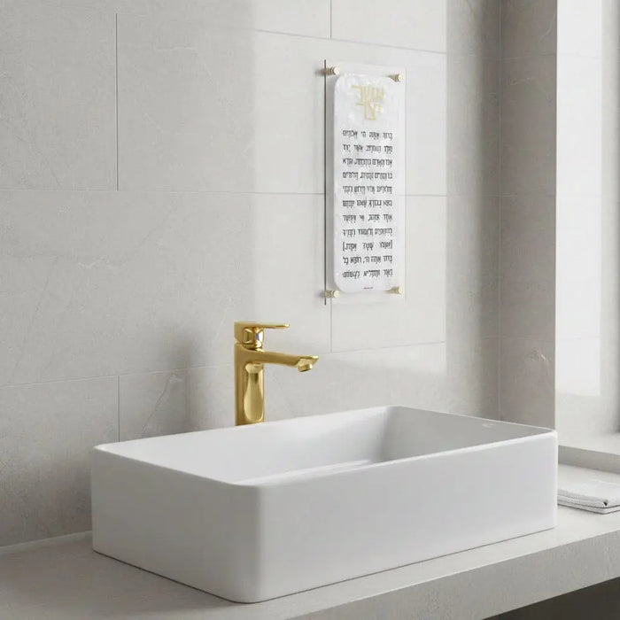 Pearlstone Asher Yatzar white marble wall art hanging above a minimalist bathroom sink with gold faucet