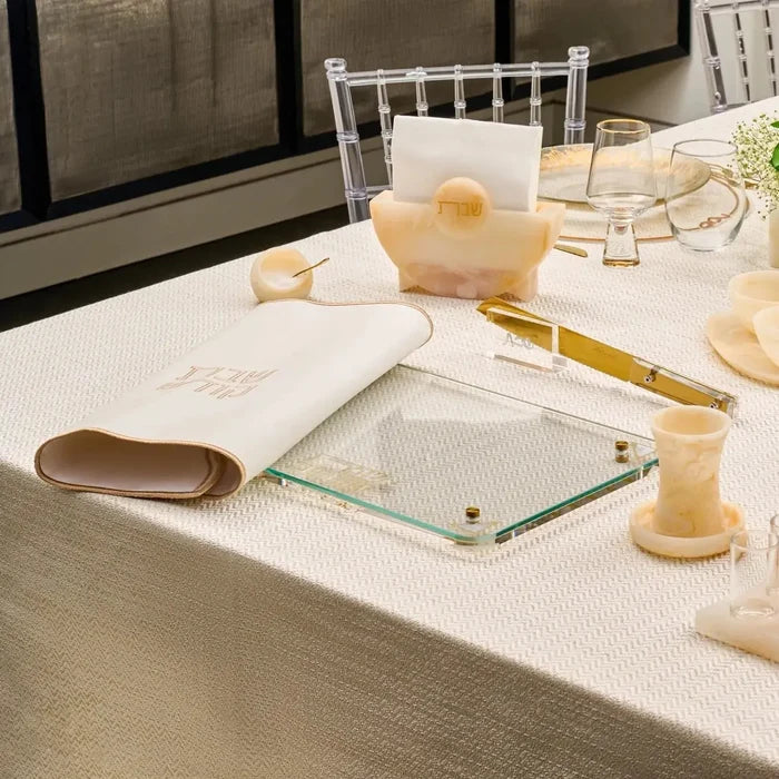 Pearlstone Challah Board with gold accents and leather handles displayed on white table with Shabbat items and beverage