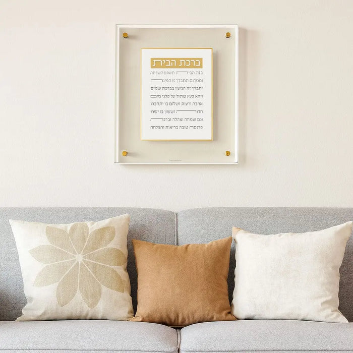 Pearlstone Frame Birchas Habayis wall art with Hebrew text displayed above gray sofa with decorative pillows