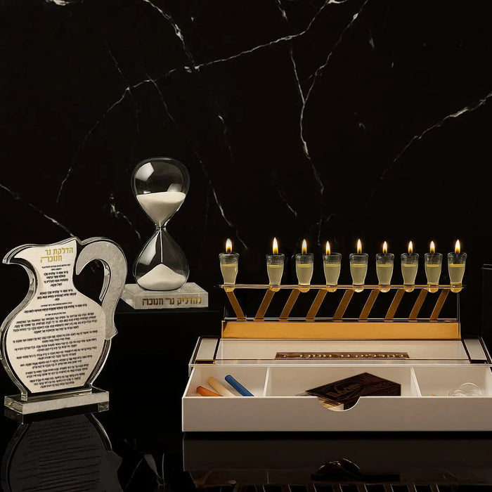 A Waterdale Collection Chanukah set-up in gold - a Lucite menorah tray laid out with oil cups and candle holders, ready for lighting
